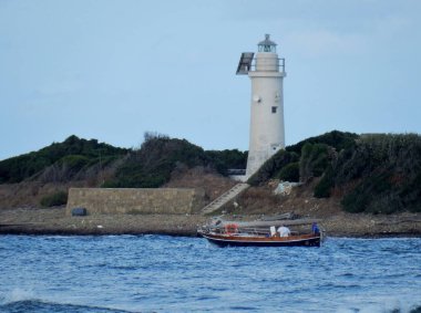 Castellabate, Salerno, Campania, İtalya - 2 Temmuz 2017: deniz feneri ile Licosa Adası ve Punta Licosa anakara arasında deniz dar streç geçiş küçük tekne