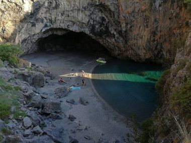 Praia a Mare, Cosenza, Calabria, İtalya - 3 Haziran 2017: mağara ve güneşli bir öğleden sonra ray tarafından aydınlatılmış Arcomagno küçük plaj
