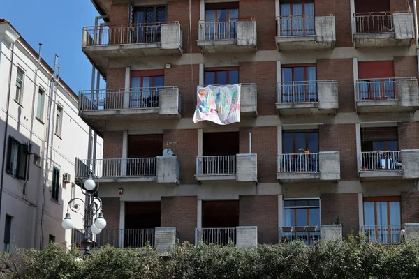 Benevento, Campania, İtalya - 15 Nisan 2020: Bir apartman dairesi balkonuna bağlı umut bayrağı
