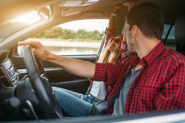 Couple sitting in the car listening to music and having fun. Enjoy a fun journey