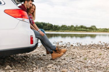 Araba açık bagaja oturan Çift 