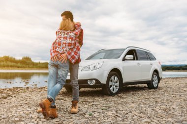 Genç çift araba ve nehir yakınında