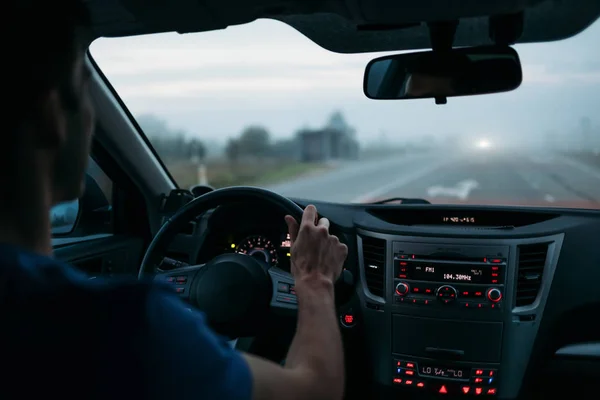 Человек за рулем автомобиля в тумане — стоковое фото