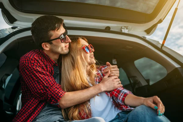 Pareja sentada en el maletero abierto — Foto de Stock