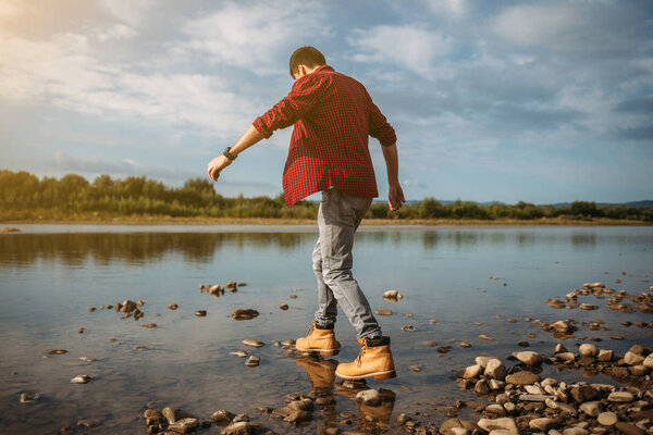 Hiker man crossing the river 