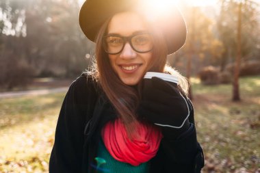 Kız güneşli sonbahar parkta yürüyüş