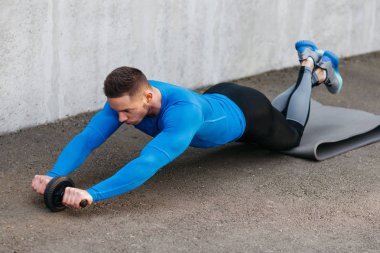 Kaslı vücut geliştirmeci adam rulo