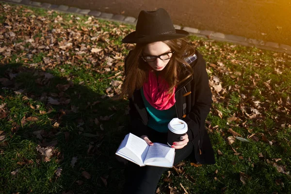 Jovem com livro e café no parque — Fotografia de Stock