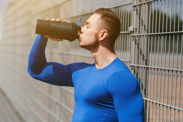 Jonge sportman met een fles water — Stockfoto