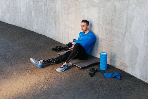 Giovane sportivo ascoltando musica — Foto Stock