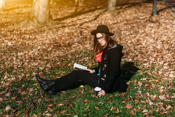 Jovem com livro e café no parque — Fotografia de Stock