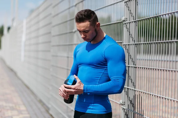 Jeune sportif avec une bouteille d'eau — Photo