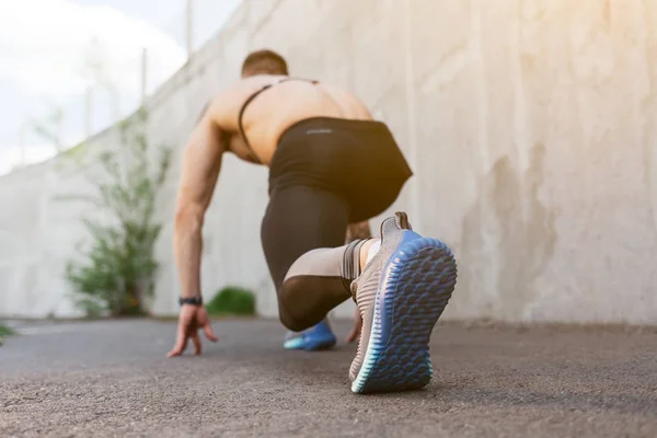 Atleet man in running start pose — Stockfoto