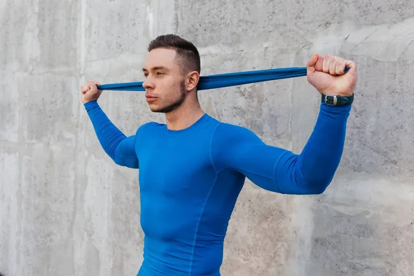 Gespierde bodybuilder man met rubber band — Stockfoto