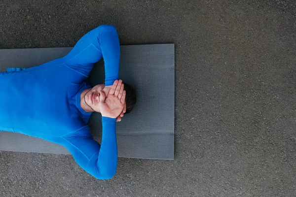 Hombre de deportes relajándose en una alfombra — Foto de Stock