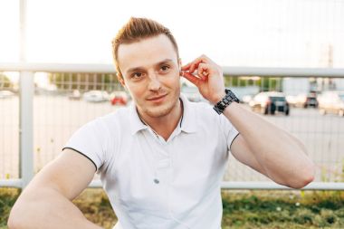 Park yerinde akıllı telefon kullanan adam