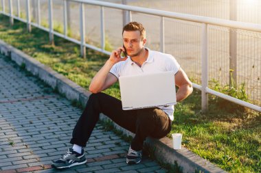 Dizüstü bilgisayar ve telefon üzerinde Park adam