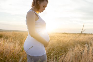 Gün batımı alanındaki hamile kadın
