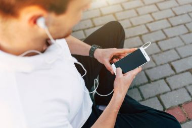 Park yerinde akıllı telefon kullanan adam