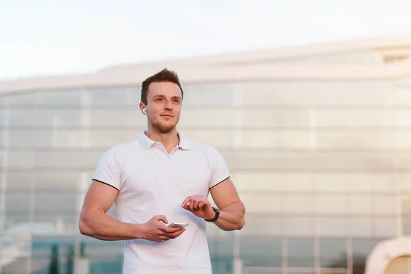 Hombre usando smartphone por edificio del aeropuerto — Foto de Stock