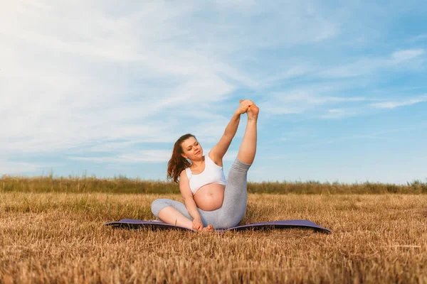 Mujer embarazada realizando yoga al aire libre — Foto de Stock