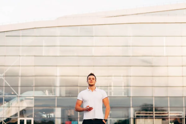 Man met smartphone door luchthavengebouw — Stockfoto