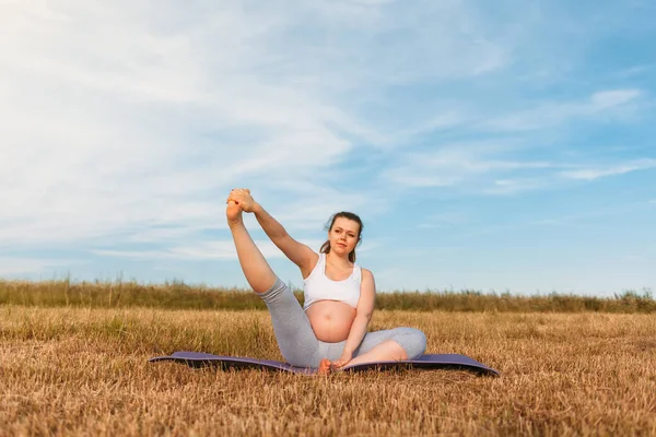Mujer embarazada realizando yoga al aire libre — Foto de Stock