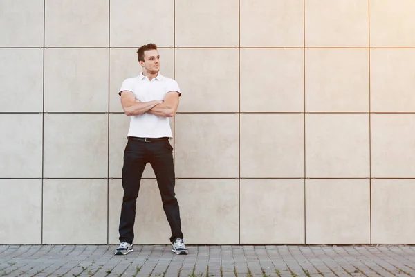 Homem musculoso em pé perto da parede — Fotografia de Stock