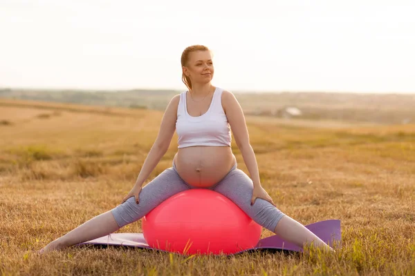 Kobieta w ciąży, wykonując jogi odkryty — Zdjęcie stockowe