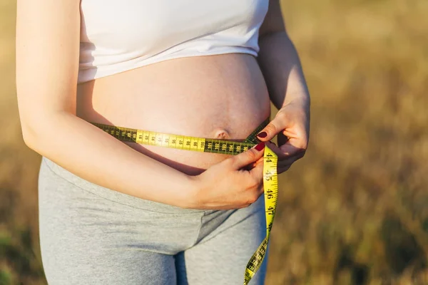 Pregnant woman measures the volume of stomach