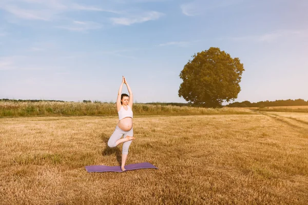 Mujer embarazada realizando yoga al aire libre — Foto de Stock