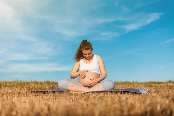 Беременная женщина, занимающаяся йогой на открытом воздухе — стоковое фото