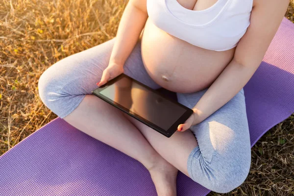 Έγκυος γυναίκα με tablet σε εξωτερικούς χώρους — Φωτογραφία Αρχείου