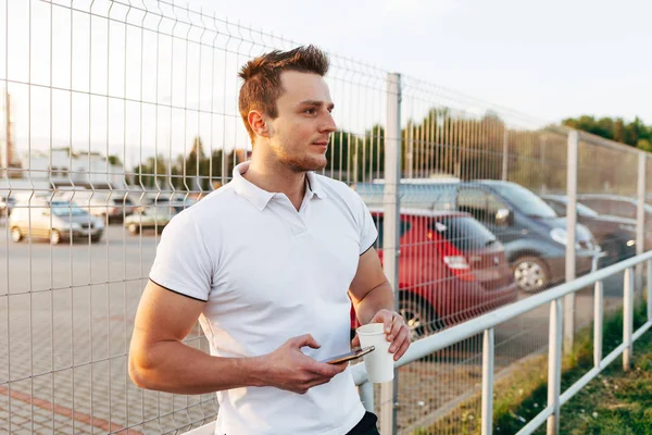 Homem usando smartphone no estacionamento — Fotografia de Stock