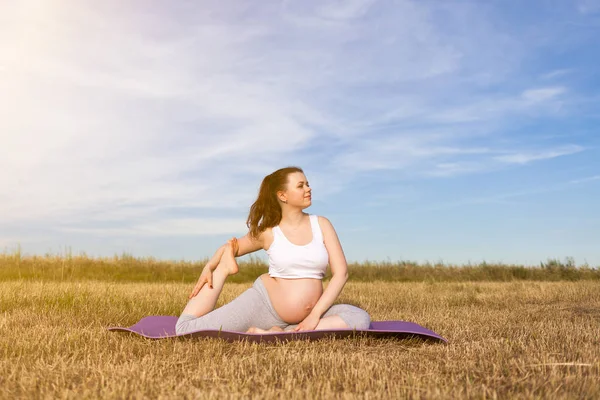 Mujer embarazada realizando yoga al aire libre — Foto de Stock