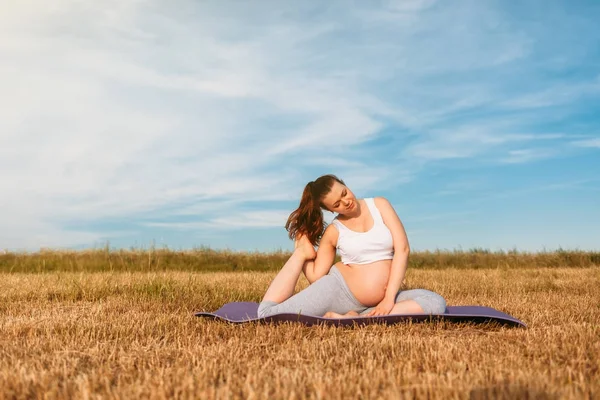 Mujer embarazada realizando yoga al aire libre — Foto de Stock