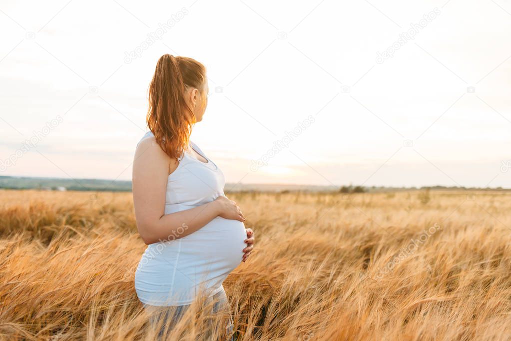 Pregnant woman in sunset field