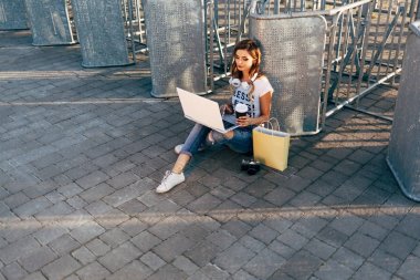 Kadın kaldırımda dizüstü bilgisayar kullanarak
