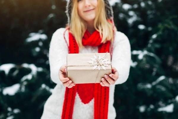 woman in winter clothes holding gift