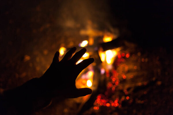 Hand near the fire. Fire. Fireplace. Travels. Cold. Heat. Get warm.