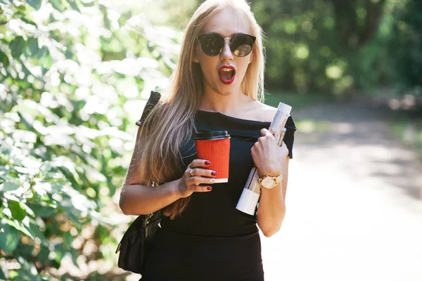 Donna con riviste e caffè nel parco — Foto Stock