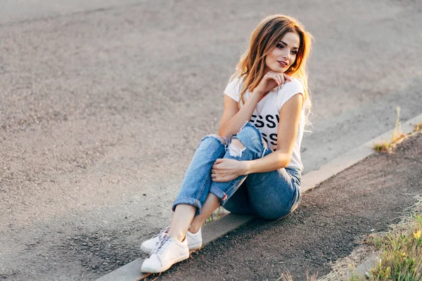 Woman sitting on side of road — Stock Photo, Image