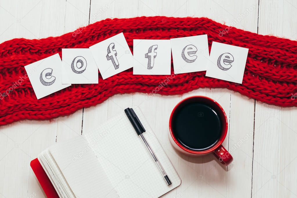 Coffee in red cup, notebook with pen and word 