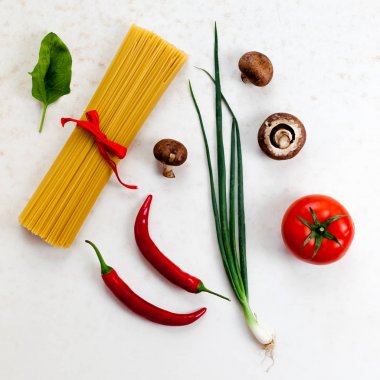 Üstten Görünüm beyaz yüzey üzerinde sos için ham spagetti ile kompozisyon ve ingridients vurdu