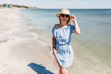 Sahilde hasır şapkalı kadın