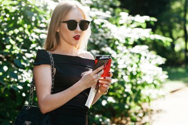 kadın smartphone kullanarak güneş gözlüğü