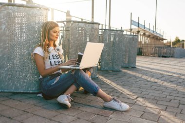 Kadın kaldırımda dizüstü bilgisayar kullanarak