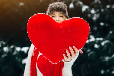 kalp şeklinde yastık tutan kadın