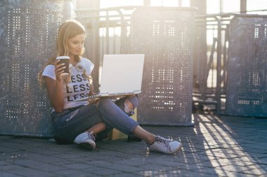 Kadın kaldırımda dizüstü bilgisayar kullanarak