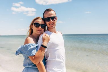 Genç çift denize sıfır kumlu plaj boyunca yürüyüş seyahat